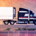 black and white striped semi truck driving down highway