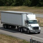 white semi truck driving down highway