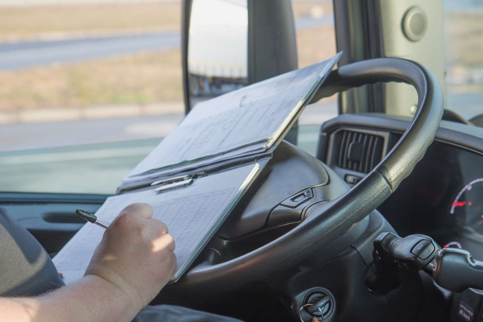 writing logs in front seat of truck