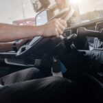 man with hands on wheel in truck cab