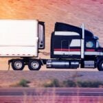 black and white striped semi truck driving down highway