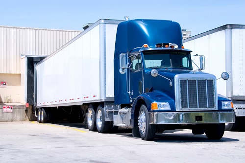 bue semi truck backed into a loading dock