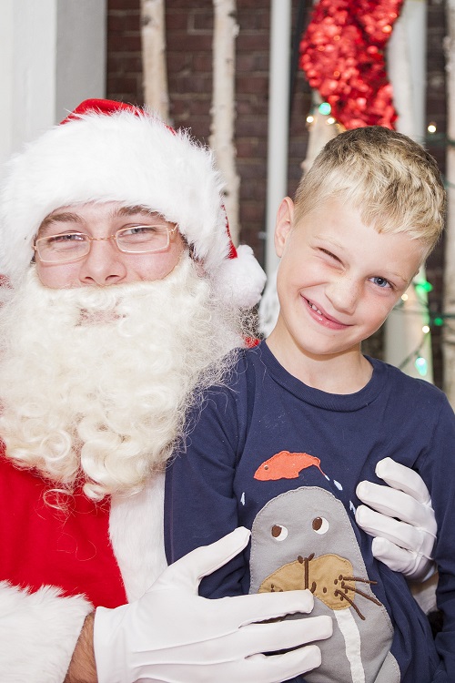 boy sitting on santa's lap and winking