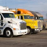 three semi trucks parked in a parking lot